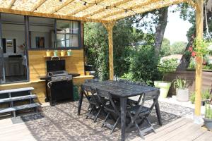 a black table and chairs on a patio with a stove at Le Mobil home de Domi in Puget-sur Argens