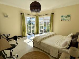 a bedroom with a bed and a large window at Sea view Ginger apartment in Pointe aux Biches
