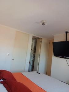 a bedroom with a bed and a flat screen tv at Hermosa vista bahía Valparaíso in Valparaíso