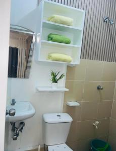 a bathroom with a toilet and a sink and towels at Z House of Guests 3 Airport Dvo in Davao City