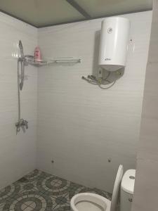 a bathroom with a toilet and a light on the wall at Appartement meublé in Saint-Louis