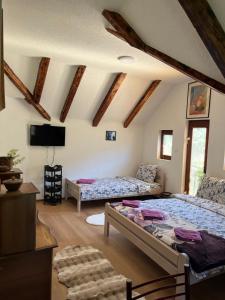 a bedroom with two beds in a room with wooden ceilings at NINA Apartmani in Plav