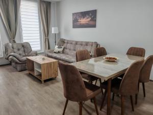 a living room with a table and a couch at Six Windows Apartmani in Bačka Topola