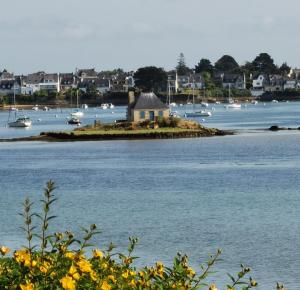 a small island in a body of water with boats at La maison Kerserho in Plouhinec