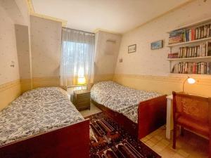 1 dormitorio con 2 camas y estante para libros en La Clé de Marc, en Le Vésinet 1 foto más