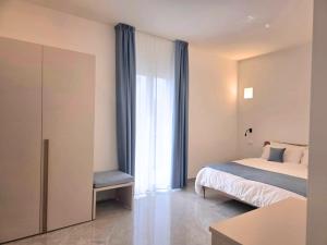a bedroom with a bed and a chair next to a window at Just Light in San Leone +16 photos