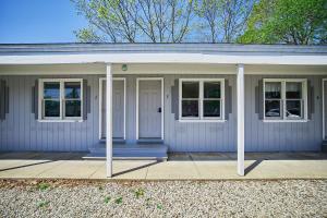 a white house with a porch and windows at Marvin Gardens Motel Old Orchard Beach in Old Orchard Beach