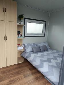 a small bedroom with a bed and a window at Róisín's Country cabin in Milltown Malbay