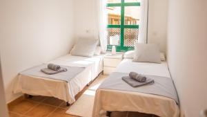 three beds in a room with towels on them at Villa Luisa - Relax with Ocean View and Pool in San Miguel de Abona +52 photos