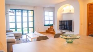 a living room with a table and a television at Villa Luisa - Relax with Ocean View and Pool in San Miguel de Abona
