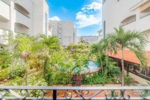 an apartment balcony with palm trees and a swimming pool at Ideal Group Getaway 4 blocks to the Beach & Pool in Playa del Carmen +31 photos