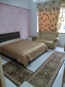 a bedroom with a bed and a couch and rugs at Furnished 1 Bedroom Apartment in Fier Kyengritja in Fier