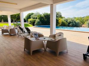 a patio with chairs and tables and a pool at Hotel Don Rodrigues in Tavira