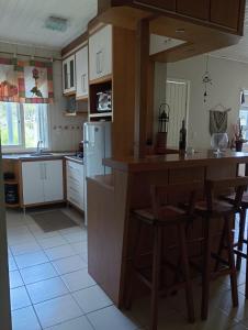 a kitchen with a large island in a kitchen at Casa Verde do Lago in São Francisco de Paula +21 photos