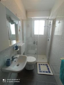 a bathroom with a sink and a toilet and a shower at Appartamento al mare in Eraclea Mare