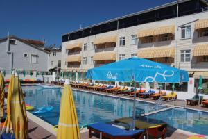 a swimming pool with umbrellas and chairs and a hotel at Aydın Motel in Marmara