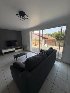 a living room with a couch and a large window at Appartement cosy avec terrasse au calme in Urcuit