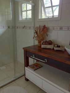 a bathroom with a sink and a shower at Casa Verde do Lago in São Francisco de Paula