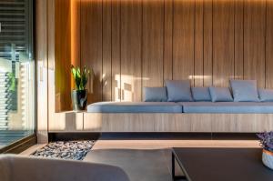 ein Wohnzimmer mit einer blauen Couch an einer Holzwand in der Unterkunft POA Heart Stay - Vista para o Guaíba no Centro Médico de Porto Alegre in Porto Alegre