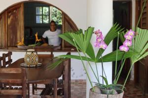 a man in a kitchen with a table and some plants at Ecolodge Vientos de Yubarta in Nuquí