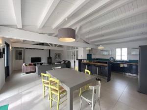 une cuisine et une salle à manger avec une table et des chaises dans l'établissement La Villa du Platin, à La Flotte 14 autres photos