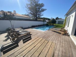 a deck with lounge chairs and a swimming pool at La Villa du Peu des Hommes in La Couarde-sur-Mer