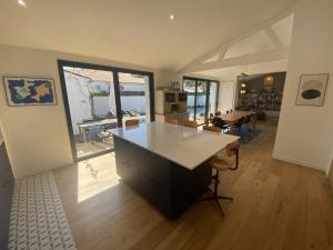 a kitchen with a large white island in a room at La Villa du Peu des Hommes in La Couarde-sur-Mer