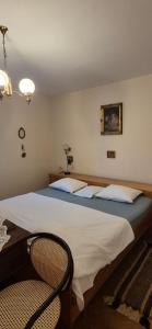 a bedroom with a large bed and a chair at Senia Retro in Senj