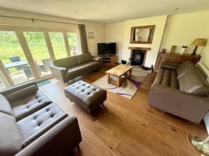 a living room with couches and a table and a television at Meadow Shores - Part of the The Bay Filey Holiday Village with pool, gym and direct beach access, pub, restaurant, tennis and meadows walks in Filey