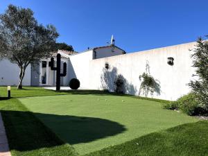 La Villa du Bois Henri IV في لا كوردي سور مير: منزل مع ساحة خضراء مع مبنى