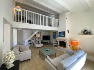 La Villa du Bois Henri IV في لا كوردي سور مير: غرفة معيشة مع أريكة ومدفأة