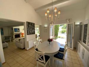 La Villa du Bois Henri IV في لا كوردي سور مير: غرفة طعام وغرفة معيشة مع طاولة وكراسي