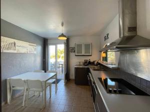 cocina con mesa blanca y sillas en La Villa de la Cible, en Saint-Martin-de-Ré