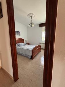 a bedroom with a bed and a chandelier at Fogar do Faustino,Rianxo by Cristian&Tamara "alquileres" in Rianjo