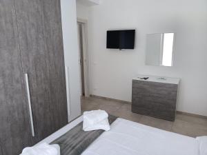 a bedroom with a bed and a tv on a wall at sosta modicana in Modica