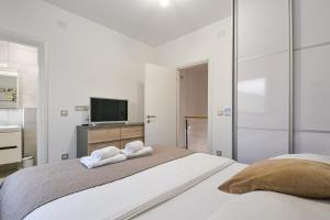 a white bedroom with two towels on a bed at Villa Insula in Linardići +51 photos