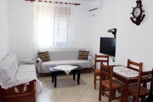 a living room with a couch and a table and chairs at Castle View Apartment in Gjirokastër