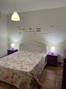 Dormitorio con cama con escrito en la pared en La Dolce Dimora, en Imola