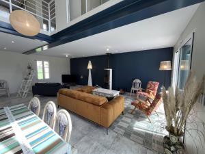 een woonkamer met een bank en een tafel bij La Villa l Olivier in La Flotte