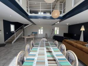 een eetkamer met een lange tafel en stoelen bij La Villa l Olivier in La Flotte