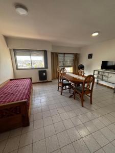 a living room with a table and chairs and a kitchen at Apartamento Pacifico Delta Suites in Bahía Blanca