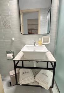 a bathroom with a sink and a mirror and towels at Filio rooms in Kythira
