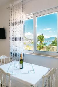 a dining room with a table and two chairs and a window at Mariana Apartments in Sarandë