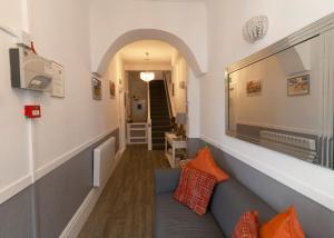 a hallway with a blue couch with orange pillows at The Aldor in Skegness