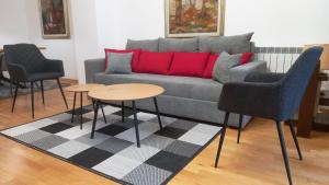 スコピエにあるArt Galerija Apartment Skopjeのソファとテーブル2つがあるリビングルーム