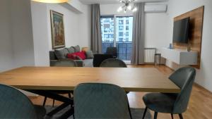 スコピエにあるArt Galerija Apartment Skopjeの木製のテーブルと椅子のあるリビングルーム