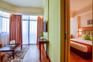 a hotel room with a bed and a desk at Hotel Sentral Seaview @ ​Beachfront in George Town
