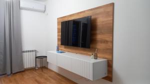 スコピエにあるArt Galerija Apartment Skopjeの壁にテレビが取り付けられたリビングルーム