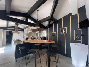 a kitchen with blue walls and bar stools at La Villa des Vignes in Les Caillaux