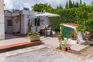 a patio with an umbrella and a table with flowers at Casa Vacanze Villa Rosa Mondello in Palermo